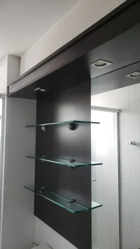 Painel para banheiro com prateleiras de vidro e iluminação embutida