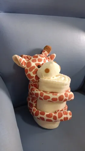 Pelúcia Girafa abraçando cobertor