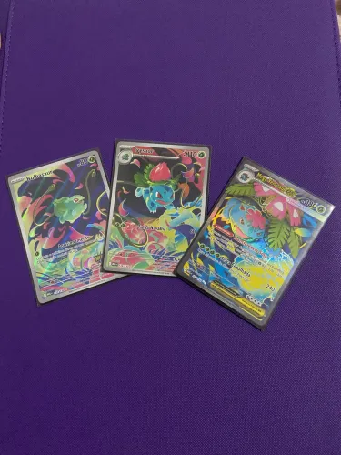 Trio de cartas Pokémon TCG - arte continuada Bulbasaur e evoluções