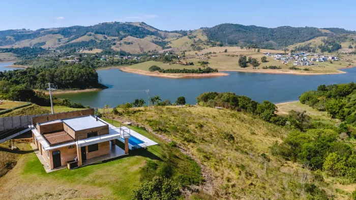 Casa com piscina de frente para represa, floresta