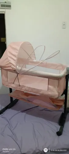 Berço portátil rosa.