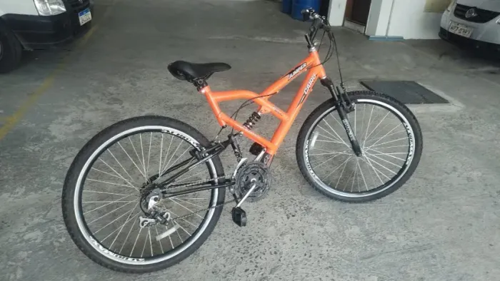 bicicleta mountain bike aro 26 com suspensão total (full suspension) e quadro alaranjado