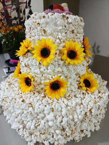 Bolo de pipoca para enfeitar sua festa junina. . Com girassóis ao redor e  chapéu no topo