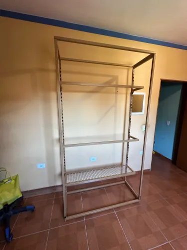 Arara de roupas dourada com prateleiras