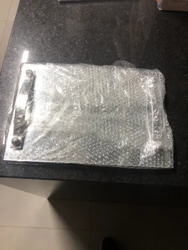 Bandeja de vidro espelhado com pés laterais de metal em formato retangular. 