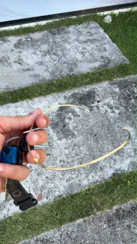 um colar choker de aro rígido (ou gargantilha em aro) dourado.