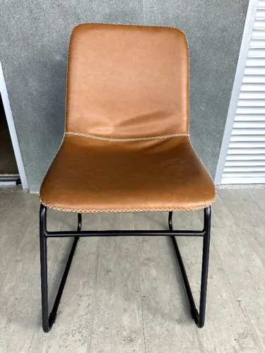 Cadeiras modernas em couro caramelo, estrutura metálica preta