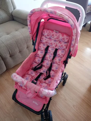 Carrinho de bebê rosa de menina em estado de novo