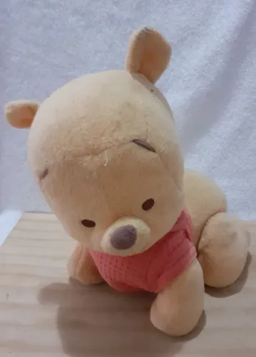Ursinho Pooh de Pelúcia, funciona a pilha, engatinha,toca música e fala.