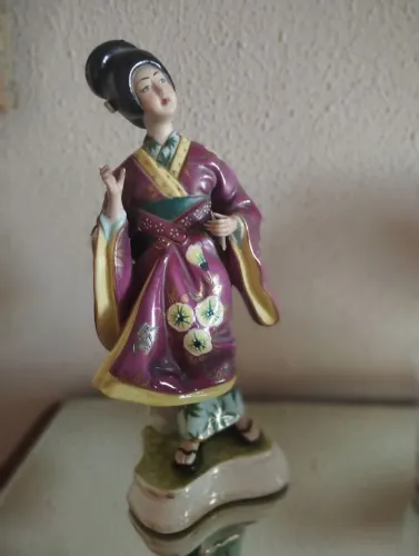 Estatueta de gueixa em porcelana