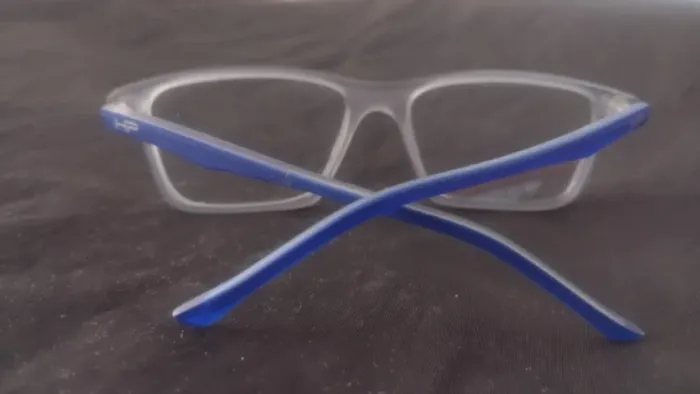 armação óculos elegante, transparente cinza claro haste azul vibrante.