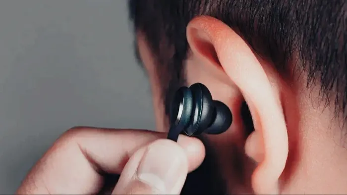 Fones de ouvido com fio, com controle de volumes acoplado.