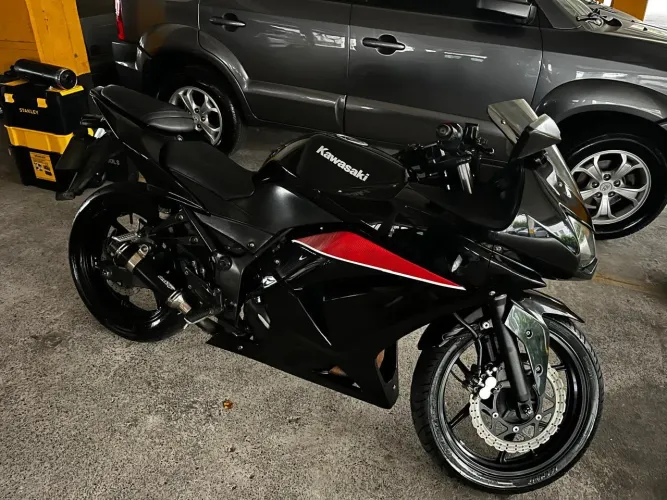Vendo Kawasaki Ninja 250R 2011, cor preta com detalhes vermelhos.