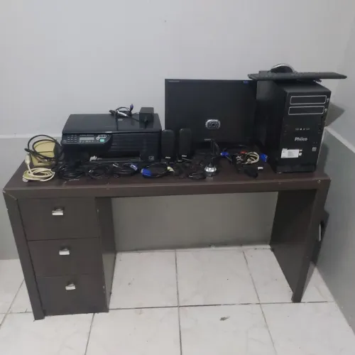 Mesa de computador com tudo em cima