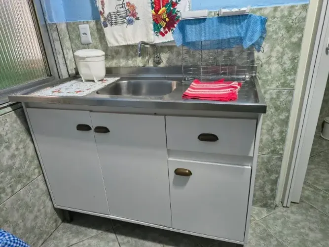 Cozinha completa com balcões e pia de inox usados branco.