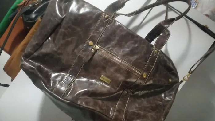 Bolsa de viagem de couro legítimo com duas alças uma de mão e de ombro .