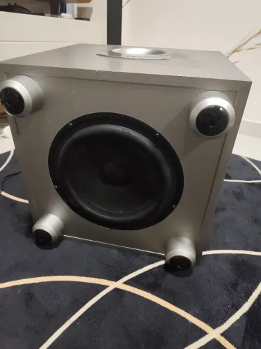 Subwoofer ativo JBL180 ou Sub 200, com potência que varia entre 100W e 150W RMS.