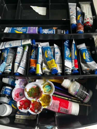 Cavalete de pintura e maleta com tintas