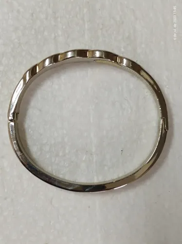 137. Bracelete de ródio branco com apliques dourados, dimensões internas 5,5cm x 5,0cm 
