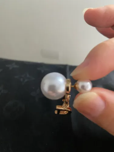 Brincos dourados de pérolas com estrela da Christian Dior 