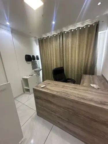 Sala no centro de Campo Grande, com dois ar condicionados, mesas, cadeiras e armários.