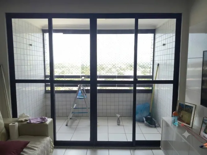 Vendo porta para varanda de vidro fumê, com esquadria de alumínio preto.