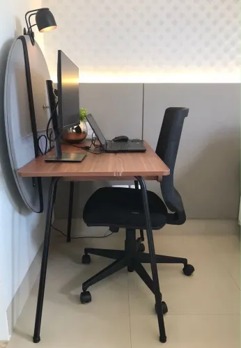 Mesa de escritório com painel e luminária