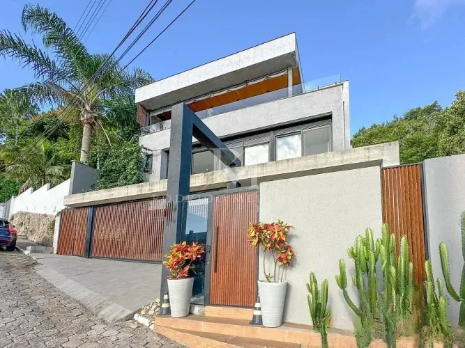 Casa com 3 suítes e vista mar em condomínio no Cacupé/SC