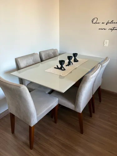 Cadeiras e mesa de jantar com tampo de vidro e pés de madeira 