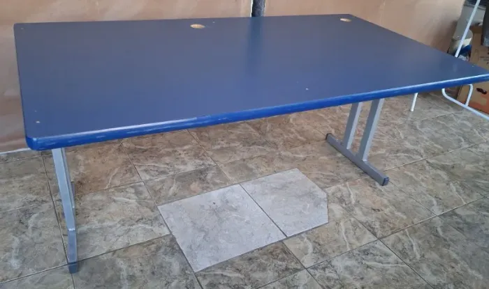 Mesa para escritório azul com pés de aço.