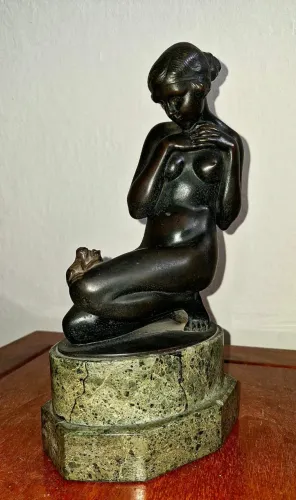 Escultura de nu feminino ajoelhado