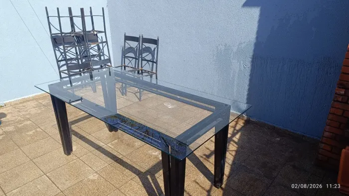 Mesa de vidro e jogo de cadeiras em ferro.