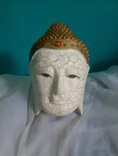 Antiga e delicada máscara de Buda branca e dourada