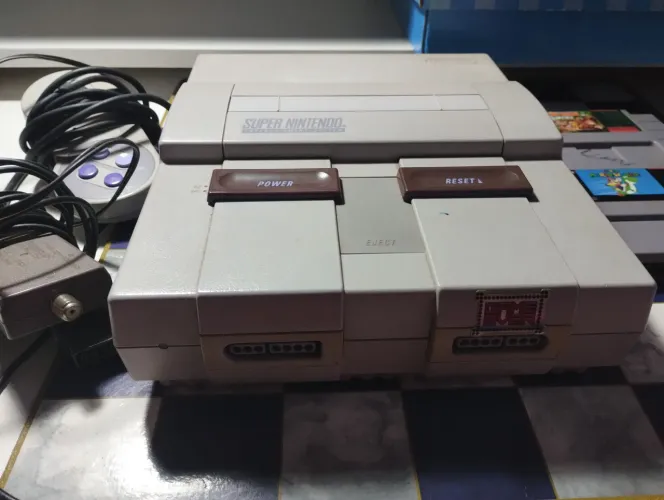 Console super Nintendo com um controle, acessórios e cartuchos