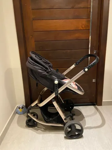 Carrinho de bebê com bebê conforto e base para carro.