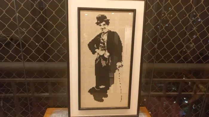 Quadro em ponto cruz / bordado à mão do Charles Chaplin, moldura dupla. Medidas 45 x 73 cm
