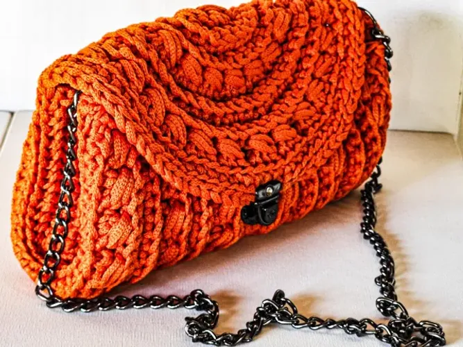 Carteira Clutch de crochê com fecho em ródio, possui alça de corrente.