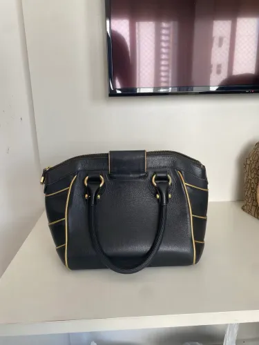     Bolsa Carmen Steffens preta com detalhes dourados. Original 