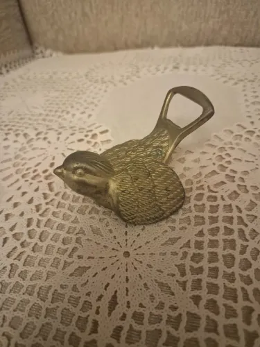 Abridor de garrafa antigo em metal prateado, em formato de andorinha
