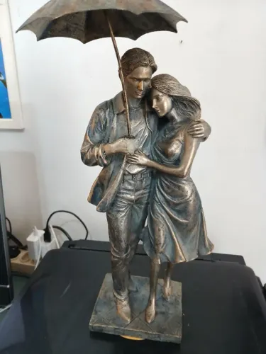 escultura de resina de um casal romântico debaixo de um guarda-chuva