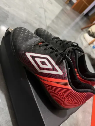 Vendo chuteira Umbro preta com detalhes em laranja, modelo Hustle