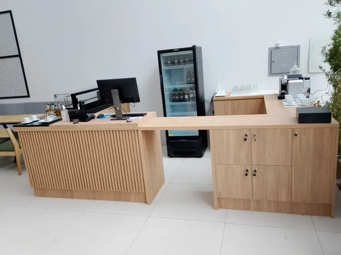 Balcão de atendimento Itapuã com pedra São Gabriel e detalhes em ripados, com armários