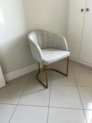 Cadeira acolchoada com pés dourados