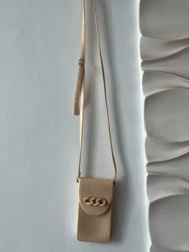 Bolsa transversal bege com detalhe em corrente