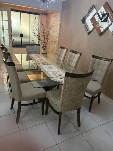 Mesa de jantar retangular medindo 2,20m x 1,10m, com 8 cadeiras. Tampo de vidro temperado