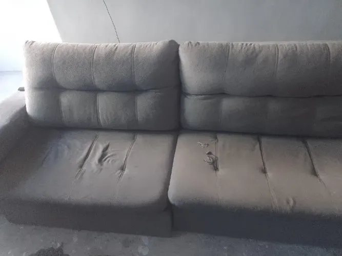 Sofá-cama usado com algumas manchas e rasgos