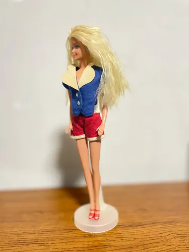 Barbie estrela, usa colete e sandálias de cartela.