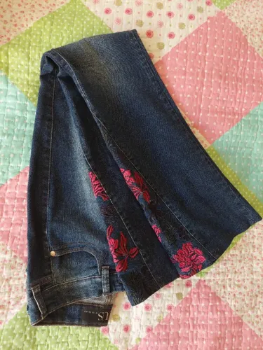 calça EQUUS denim brand, boca de sino e em lavagem escura com bordados em rosa escuro