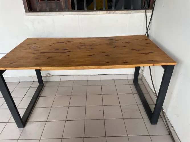 Mesa estilo industrial com estrutura metálica reforçada e tampo em madeira.