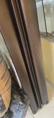Porta gigante em esquadrias de alumínio na cor bronze com vidro incolor temperado.